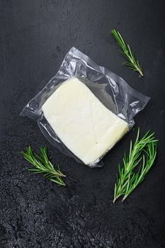 Fresh halloumi cheese, on black dark stone table background, top view flat lay, with copy space for text