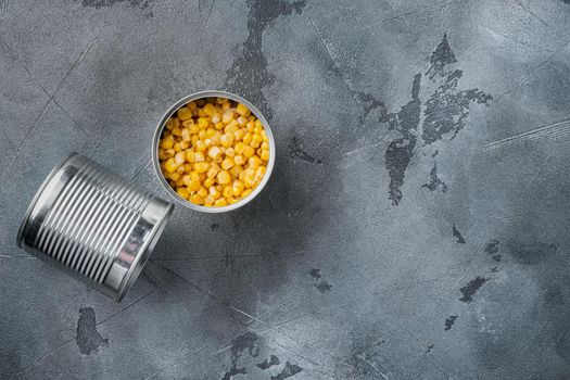 Canned sweet corn in can, on gray background, top view flat lay with copy space for text