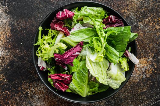 Frieze, romaine and Radicchio lettuce salad, on old dark rustic background, top view flat lay