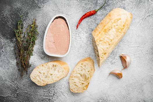 Fresh chicken liver pate from can on bread set, on gray stone table background, top view flat lay