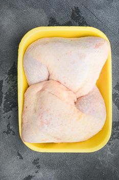 Fresh chicken leg set, in Foam Tray Pack, on gray stone background, top view flat lay