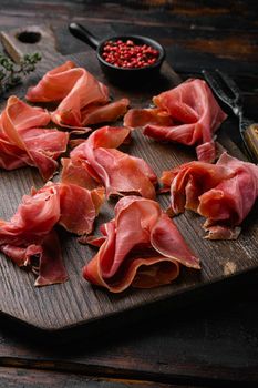 Jamon serrano. Traditional Spanish ham, on old dark wooden table background