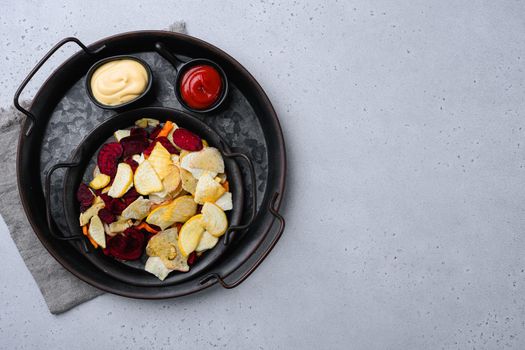 Beetroot carrot and turnip chips set, on gray stone table background, top view flat lay, with copy space for text