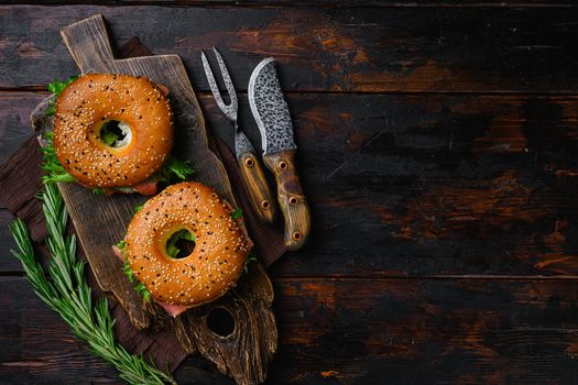 Bagel with red fish and soft cheese set, on old dark wooden table background, top view flat lay, with copy space for text