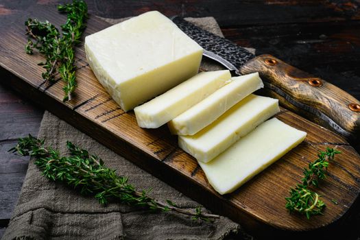 Fresh halloumi cheese, on old dark wooden table background