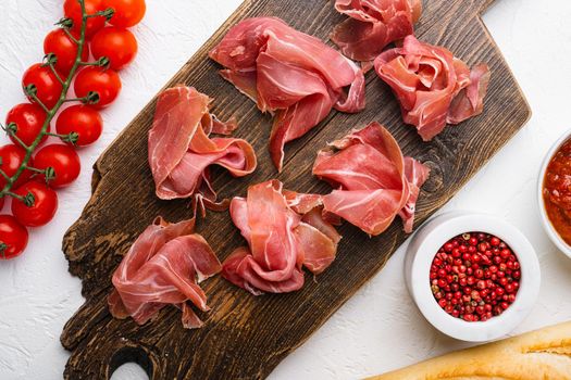 Fresh slices jamon, on white stone table background, top view flat lay