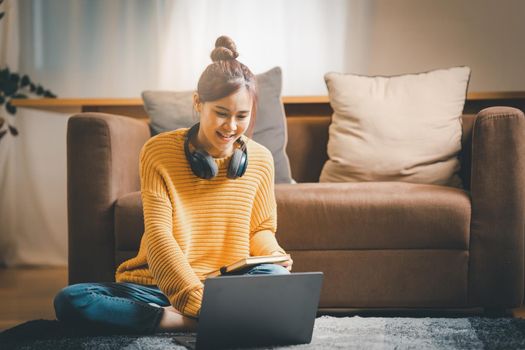 Portrait of Happy Asian artist woman using laptop computer at home