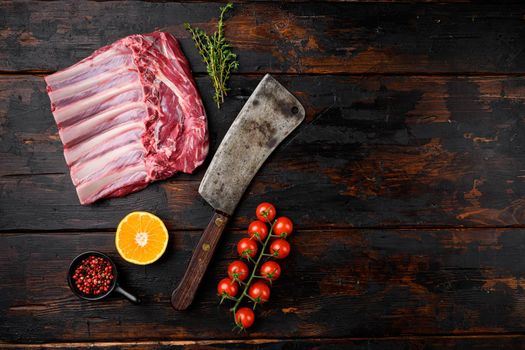 Lamb meat rib rack set, on old dark wooden table background, top view flat lay, with copy space for text