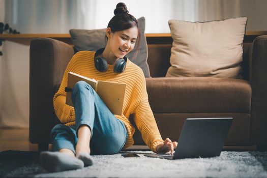 Portrait of Happy Asian artist woman using laptop computer at home