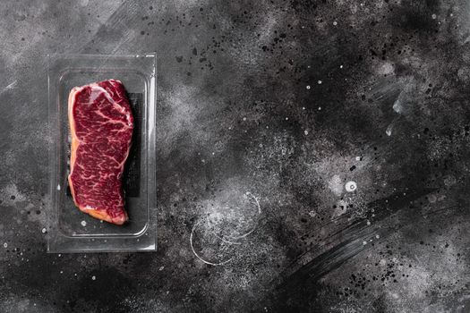 Meat in a package set, on black dark stone table background, top view flat lay, with copy space for text