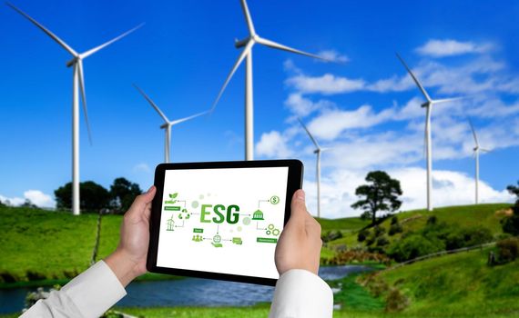 Green business transformation for environment saving and ESG business concept. Businessman using tablet to set corporate goal toward environmental friendly management and alternative clean energy use.