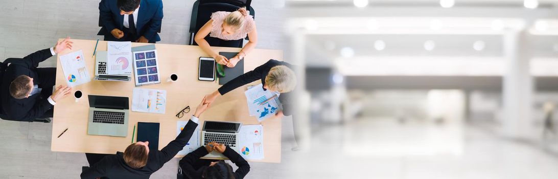 Business people group meeting shot from top widen view in office . Profession businesswomen, businessmen and office workers working in team conference with project planning document on meeting table .