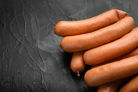 Boiled sausage set, on black dark stone table background, with copy space for text