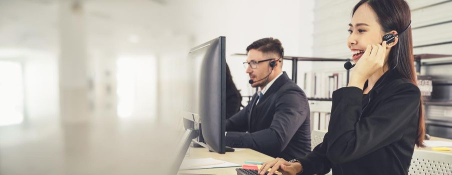 Business people wearing headset working in office to support remote customer or colleague. Call center, telemarketing, customer support agent provide service in broaden view .