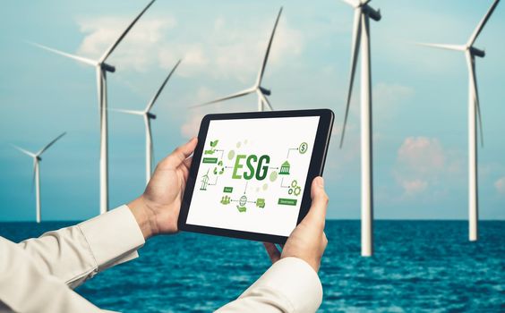 Green business transformation for environment saving and ESG business concept. Businessman using tablet to set corporate goal toward environmental friendly management and alternative clean energy use.