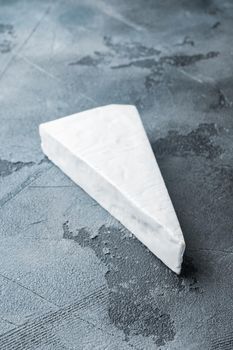 Delicious brie cheese piece, on gray background