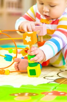Baby plays with an educational toy. Selective focus. Child.