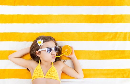 Child girl on a beach towel by the sea. Selective focus. Kid.