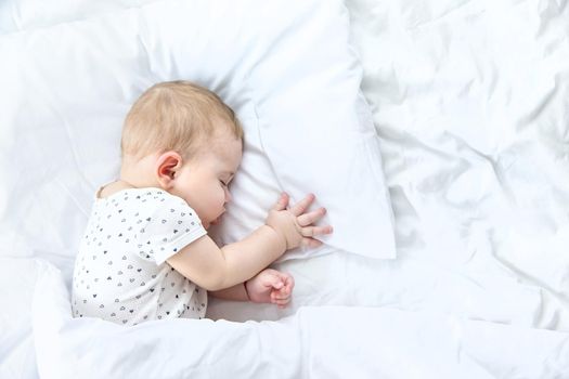 Baby sleeps on a white bed. Selective focus. Child.