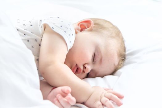Baby sleeps on a white bed. Selective focus. Child.