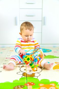 Baby plays with an educational toy. Selective focus. Child.