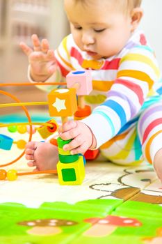 Baby plays with an educational toy. Selective focus. Child.