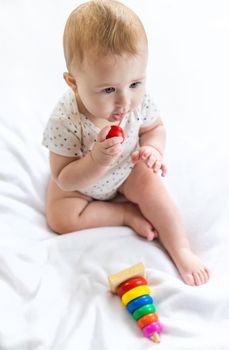 Baby plays with a pyramid at home. Selective focus. People.