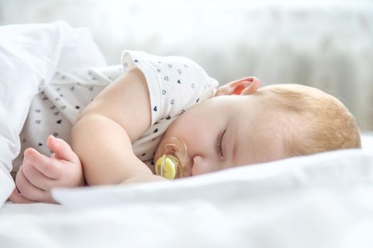 Baby sleeps on a white bed. Selective focus. Child.