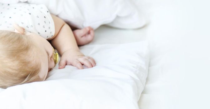 Baby sleeps on a white bed. Selective focus. Child.