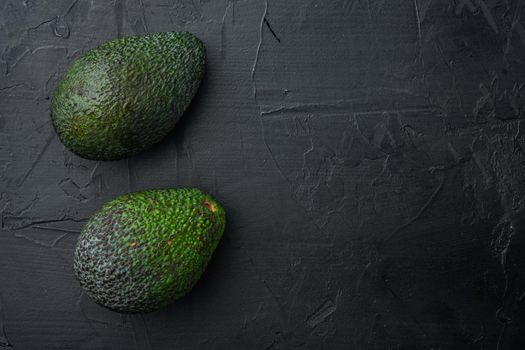 Ripe pair of green avocado set, on black background, top view or flat lay with copy space for text