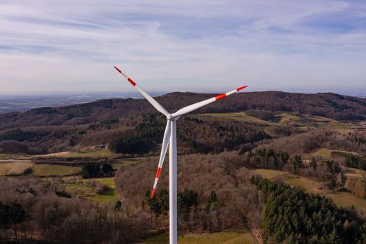 Aerial view of a wind turbine on a hill with a beautiful view