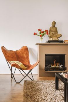 A stylish brown armchair near the fireplace