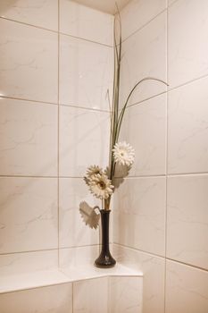 Flowers in a vase as a decor for the bathroom