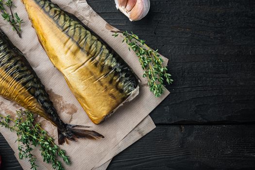 Smoked fish mackerel, on black wooden table background, top view flat lay with copy space for text