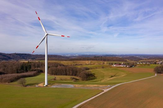 Aerial view of a wind turbine with rotor blades marked in red and white