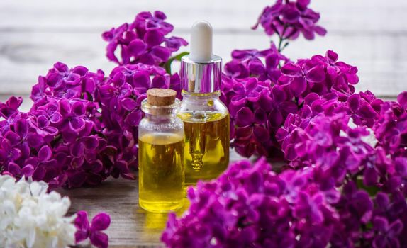 Lilac essential oil in a small bottle. Selective focus.