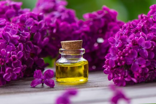 Lilac essential oil in a small bottle. Selective focus.