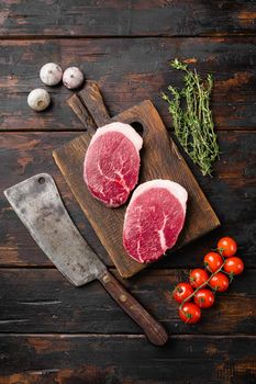 Raw tenderloin steak set, on old dark wooden table background, top view flat lay, with copy space for text