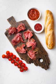 Jamon serrano. Traditional Spanish ham, on white stone table background, top view flat lay