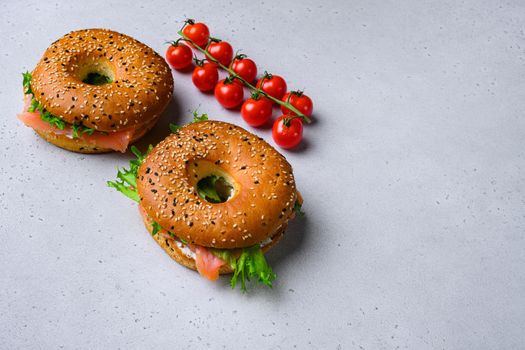 Bagel sandwich with salmon set, on gray stone table background, with copy space for text