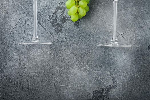 Wineglasses with grapes set, on gray stone background, top view flat lay, with copy space for text