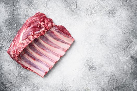 Lamb ribs cooking. Raw rack of lamb meat set, on gray stone table background, top view flat lay, with copy space for text