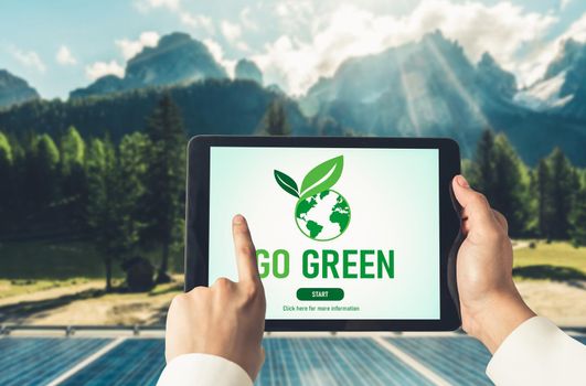 Green business transformation for environment saving and ESG business concept. Businessman using tablet to set corporate goal toward environmental friendly management and alternative clean energy use.