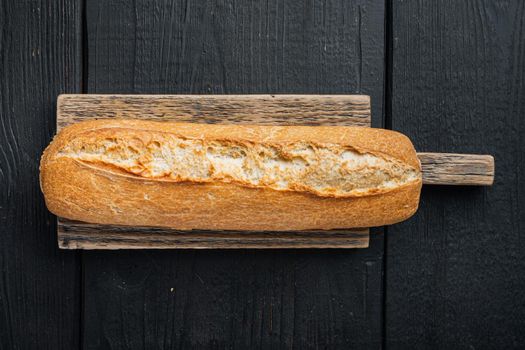 Baguette bread, on black wooden table background, top view flat lay