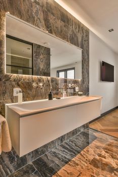 Spacious dark bathroom with shower and sink in a minimalist style