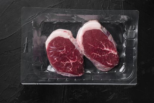 Beef steak vacuum Packed set, on black dark stone table background, top view flat lay