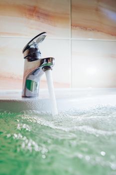 single handle faucet pouring hot water in a bath tub