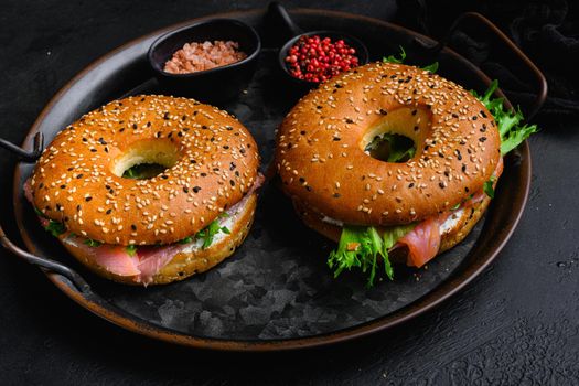 Fresh Smoked Salmon And Cream Cheese Bagel set, on black dark stone table background