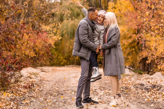 Young happy family while walking in the autumn park