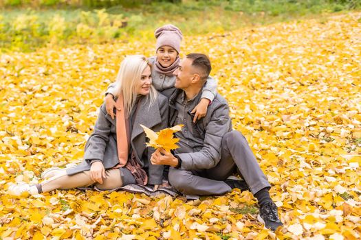 Happy family playing in autumn park.